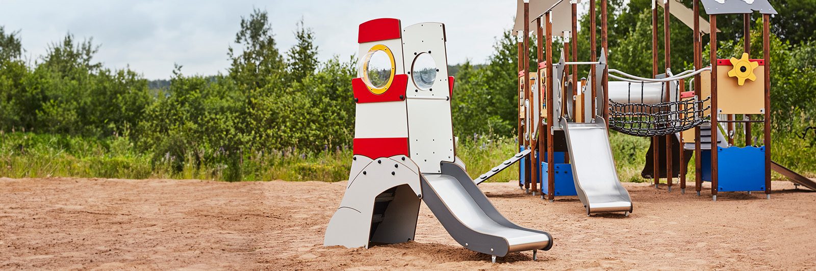 A small playground structure shaped like a spaceship with a slide.